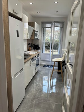 Eine moderne Küche mit Kühlschrank, Mikrowelle und Kaffeemaschine.