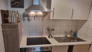 A kitchen with white cabinets, a double sink, a stove, and an oven. - Comfortable guest house – 5 rooms wth private bathroom, Wi-Fi, kitchen & parking (Meine)