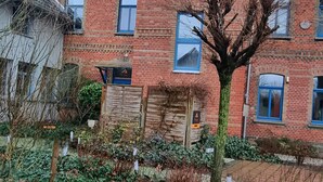 A red brick building with multiple windows and a wooden gate. - Comfortable guest house – 5 rooms wth private bathroom, Wi-Fi, kitchen & parking (Meine)