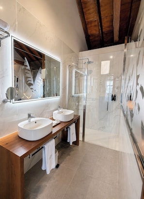 A modern bathroom with two sinks, a glass shower enclosure, and a large mirror. - Hotel Jardin Secreto (La Orotava)