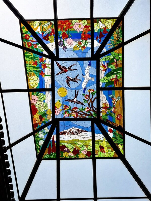 A stained glass window with a geometric pattern and floral designs. - Hotel Jardin Secreto (La Orotava)