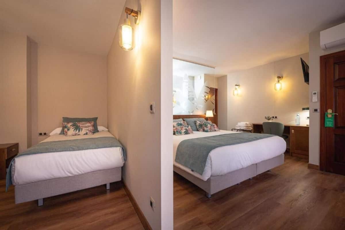 Une chambre à coucher comprenant un lit, une table de chevet, une lampe et un bureau avec une chaise.