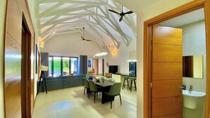 A spacious interior with a dining area, kitchen, and a bathroom with a sink and mirror. - Bin Bin Coasta Villa Ho Tram (Ho Chi Minh City)