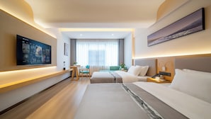 Een hotelkamer met een televisie, twee bedden, een bureau en een raam met gordijnen.
