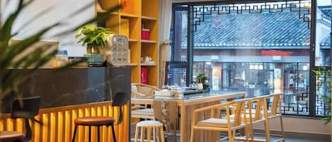 A modern interior with a dining area, wooden furniture, and a large window with a view.