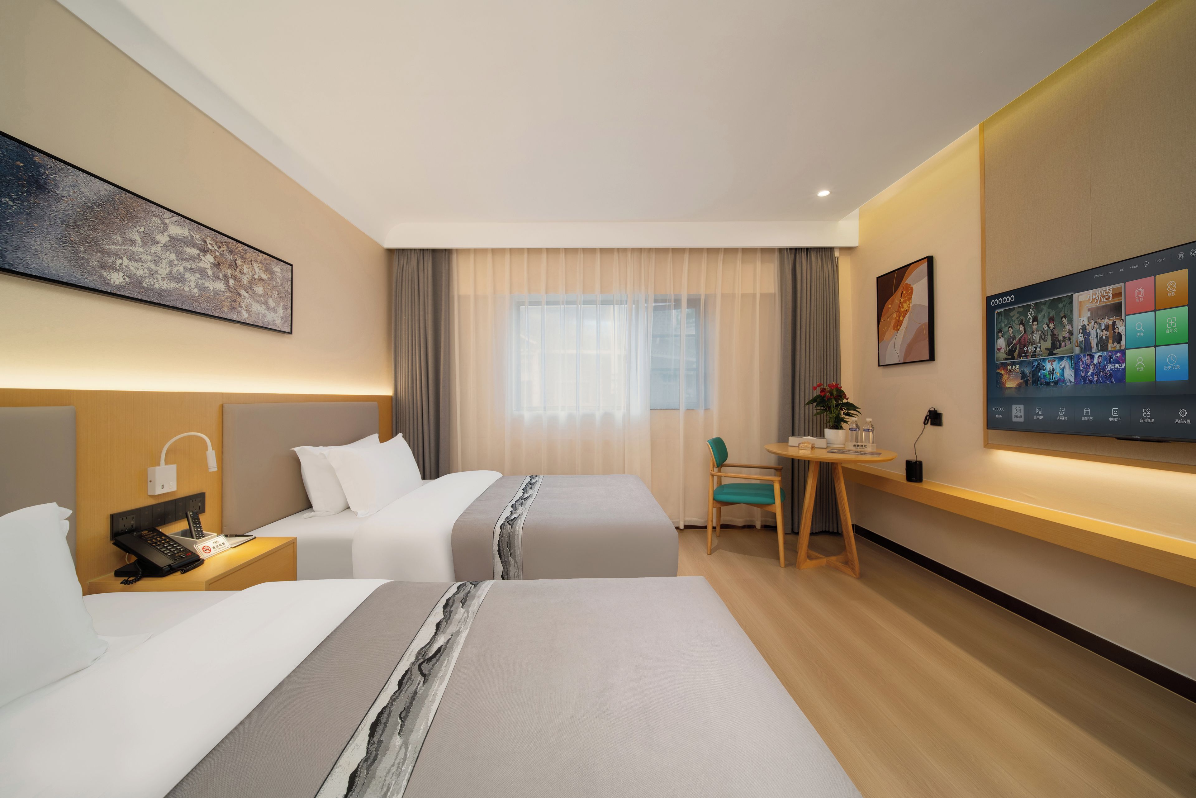 A hotel room with two beds, a desk, a chair, a TV, and a painting on the wall.