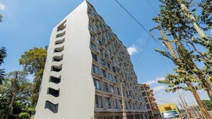 Monikerroksinen rakennus, jossa on ainutlaatuinen arkkitehtoninen ilme ja selkeästi erottuva pystysuuntainen elementti vasemmalla puolella.