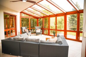 A sunroom with a large sectional sofa, two armchairs, and a small table. - EINSER - Luxury Apartment XXL (Spalt)