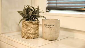 A woven basket with a plant and a candle labeled "HARMONY" on a tiled surface. - SECHSER - Easy Apartment (Spalt)