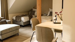 A modern, well-lit room with a sofa, a dining table, and a bed. - SECHSER - Easy Apartment (Spalt)