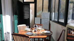 Zona pranzo con un tavolo rotondo apparecchiato per quattro, inclusi piatti, bicchieri e una bottiglia.