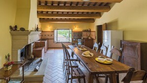 Una cocina rústica con una mesa de madera, sillas y vistas al exterior.
