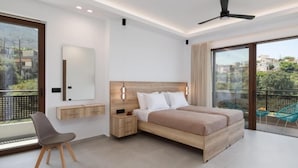 A modern bedroom with a large bed, a desk, a chair, and a balcony with outdoor seating. - O-Cyanea Villa: Luxurious 4-Bedroom Retreat with Heated Pool in Kournas (Paralia Kourna)