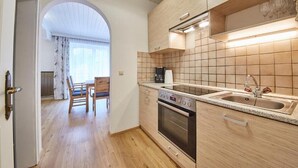 Een moderne keuken met houten kastjes, een ingebouwde oven en een ruime gootsteen.