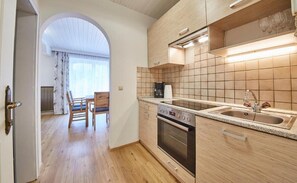 Eine moderne Küche mit Holzausstattung, einem eingebauten Backofen und einer großen Spüle.