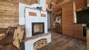 Ein rustikales Blockhaus-Interieur mit Kamin, Holzwänden und einem aufgehängten Hirschkopf.