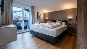 Une chambre d’hôtel moderne équipée d’un lit, d’un bureau, d’une chaise, d’une grande fenêtre offrant une vue et d’une lampe fixée au mur.