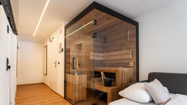 Une chambre moderne avec un lit, une armoire en bois et une cloison en verre.