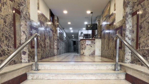 A marble staircase with metal railings leading to a reception area. - Premium RJ - Consulado (Rio de Janeiro)
