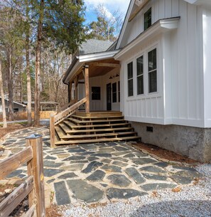 A house with a stone-paved entrance, wooden steps, and a porch.