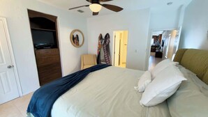 Una camera da letto con un letto, una ventola a soffitto, una TV e un armadio.