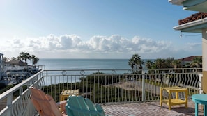 A balcony with a view of the ocean, outdoor furniture, and a railing. - Sunset Bay Views - Private 3 Levels - Rooftop Patio (South Padre Island)