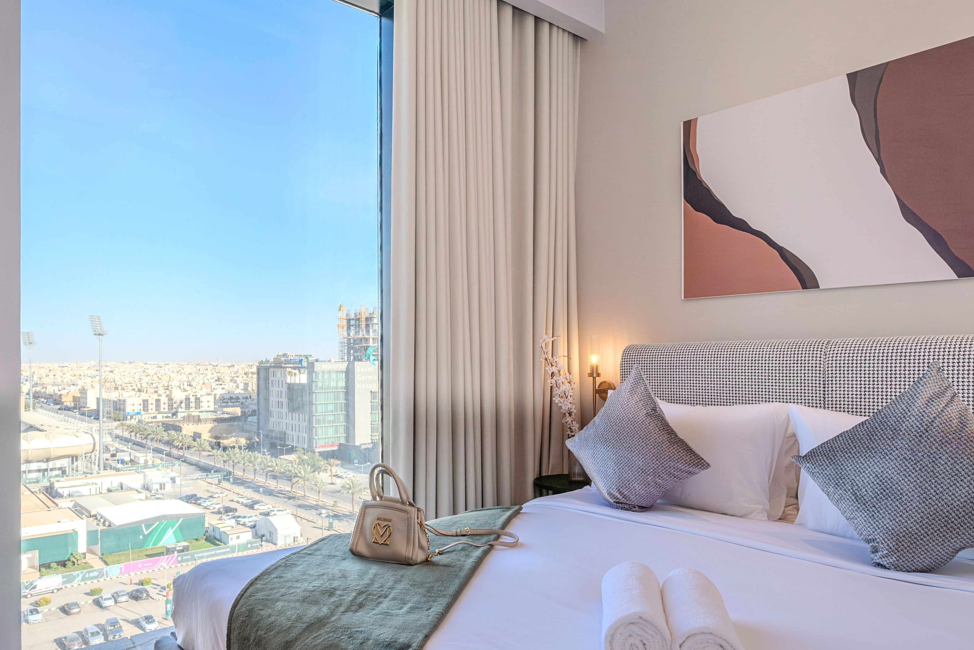 Une chambre d’hôtel avec un lit, une vue sur la ville et une grande fenêtre.