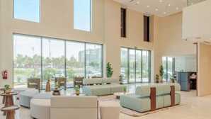 A spacious lobby with large windows, seating areas, and a reception desk.