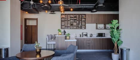 A modern kitchen with wooden cabinets, a central island, and a dining area with a round table and blue chairs.