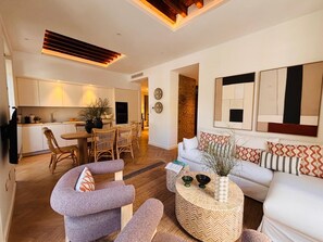 A modern apartment with a dining area, a living room with a sofa and armchairs, and a kitchen. - Elegant 3BD Apartment in Malaga Plaza Marina II (Málaga)