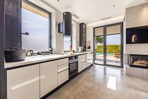 Una cocina moderna con una isla grande, horno empotrado y vistas al exterior.