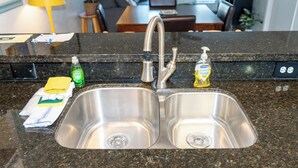 A stainless steel kitchen sink with a double faucet, a soap dispenser, and a bottle of dish soap on the countertop. - Cozy Family Retreat - Steps to Beach - Pool - Hot Tub (South Padre Island)