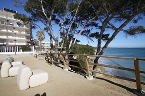 A coastal walkway with a wooden railing, a sandy path, and a building with balconies in the background. - Panoramic B6 by Parc Mont-roig Apartment (Miami Playa)