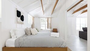 Ein Schlafzimmer mit einem Bett, einem Sessel und einem Sofa.