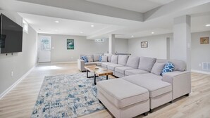 Ein modernes Wohnzimmer mit einem Ecksofa, einem Couchtisch und einem großen Teppich.
