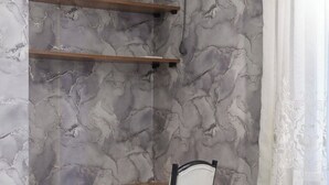 A study area with a desk, chair, and marble-patterned walls.