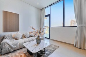 Ein modernes Wohnzimmer mit einer Couch, einem Couchtisch und einer Vase mit Blumen.