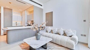 Een moderne woonkamer met een bank, een salontafel en een vaas met bloemen.