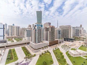 A modern urban skyline with high-rise buildings, including a prominent skyscraper. - Stylish 2BR with Burj Khalifa Views, Minutes from Marine Transport Station (Dubai)