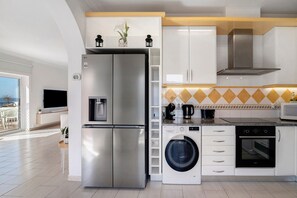 A modern kitchen with stainless steel appliances, a built-in washing machine, and a microwave. - Sunny Paradise – Ocean View Holiday Home in Albufeira for 6 Guests (Albufeira)