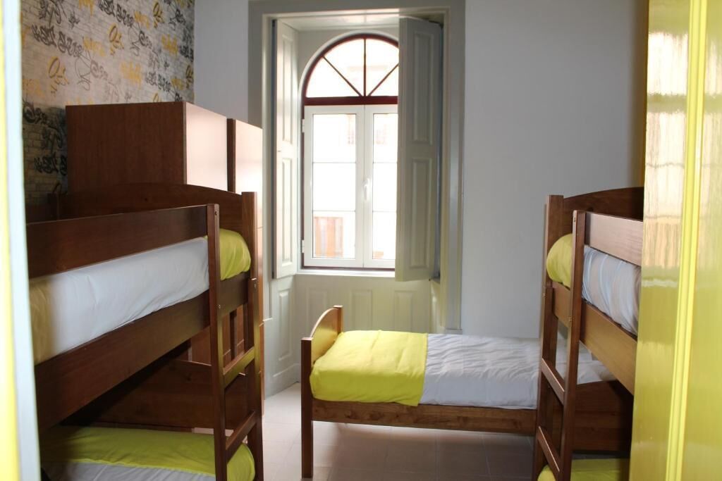 A room with bunk beds, a window with a view, and a door.