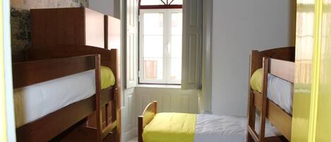 A room with bunk beds, a window with a view, and a door.