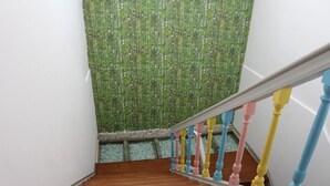 A staircase with a wooden floor and a colorful railing. - Meeting Hostel (Figueira da Foz)