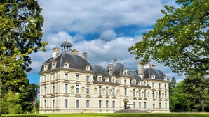 A large, historic building with multiple domes and a symmetrical facade, surrounded by lush greenery. - Furnished Cottage in the Land of Castles – Ideal for Cycling (Mont-près-Chambord)