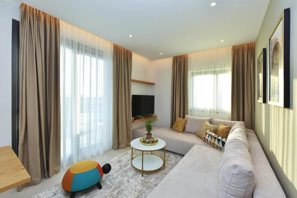 A modern living room with a sofa, a round coffee table, and a television.