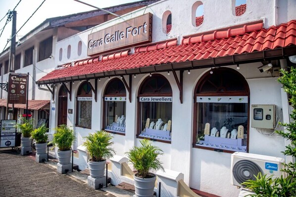 A building with a sign reading 'Cara Galle Fort' and storefronts labeled 'Cara Galle Fort' and 'Cara Jewellers.'