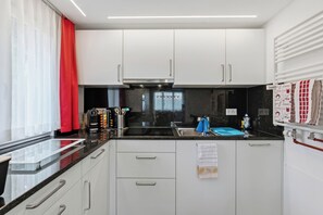 Eine moderne Küche mit weißen Schränken, einer schwarzen Arbeitsplatte und einer Siemens-Dunstabzugshaube.
