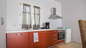 A compact kitchen with a stove, oven, and coffee maker. - Castri Village Kythira - Andromeda Sea View Escape (Kithira)
