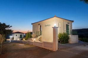 A small, single-story building with a white facade and a green door, labeled "Aquabecoa Village."