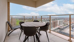 Ein Balkon mit Tisch und Stühlen und Blick auf die Stadt.